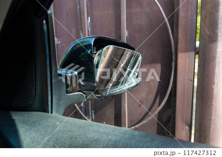 broken side window of black car in rusted gate background, view from inside broken side window of black car in rusted gate background, view from inside 117427312