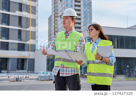 Two industrial construction workers discussing project plan for engineering work Two industrial construction workers discussing project plan for engineering work 117427320