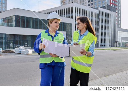 Two confident women talking working on construction of residential office building 117427321