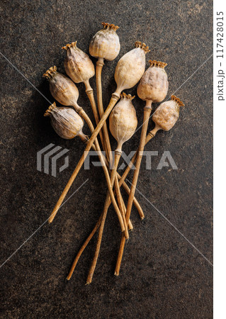 Dry poppy head on black table. Top view. Dry poppy head on black table. Top view. 117428015
