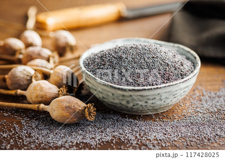 Dry head and poppy seed in bowl on kitchen table. Dry head and poppy seed in bowl on kitchen table. 117428025