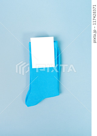 Pair of blue socks with white label. mockup for design with blank label 117428371