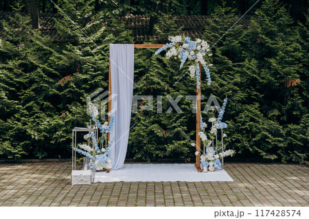 Elegant outdoor wedding arch with floral decorations for a romantic garden ceremony Elegant outdoor wedding arch with floral decorations for a romantic garden ceremony 117428574