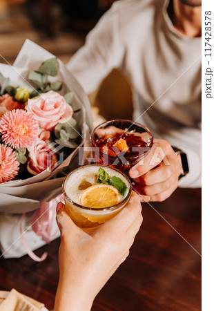 Toasting with cocktails and flowers, celebrating special moments together in a cozy atmosphere 117428578