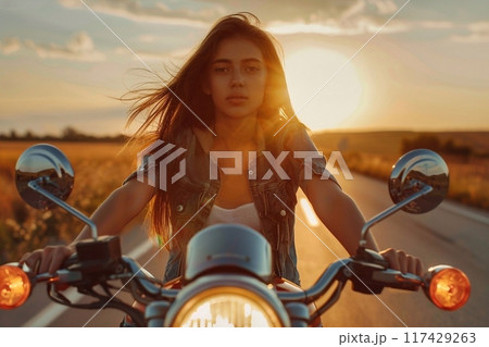 Biker girl on a motorcycle at sunset. Biker girl on the road. Biker girl on a motorcycle at sunset. Biker girl on the road. 117429263