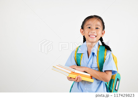Portrait Asian smiling young girl kids kindergarten hair in pigtails holding backpack hold books studio isolated white background, happy cute little schoolgirl wears school uniform, back to school 117429823