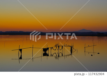 茜色に染まった夕焼け空と筑波山のシルエットを背景にした涸沼の水面と網棚の風景 Ver1 茜色に染まった夕焼け空と筑波山のシルエットを背景にした涸沼の水面と網棚の風景 Ver1 117432904