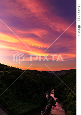 2024年夏奈良市東部布目ダムの夕景　ダム北(渓谷)側爆焼けの空　帯状に重なる茜雲と茜色の布目川① 117433231
