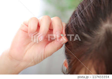 髪の毛をチェックしている40代の女性 髪の毛をチェックしている40代の女性 117433354