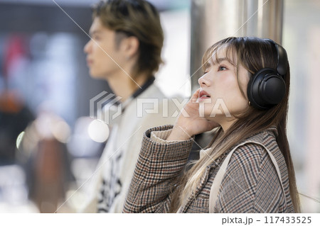 ヘッドホンをした若い女性 横顔 ヘッドホンをした若い女性 横顔 117433525