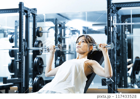 スポーツジムでトレーニングする若い女性 117433528
