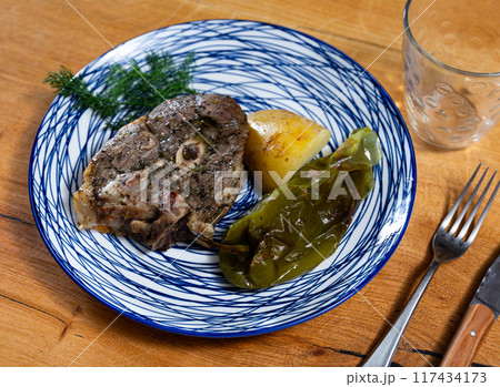 Fried lamb served with potatoes and peppers Fried lamb served with potatoes and peppers 117434173