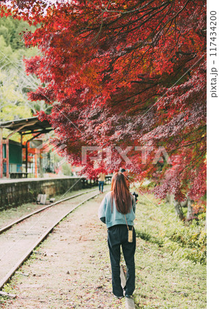 三河広瀬駅の紅葉と女性の後姿 117434200