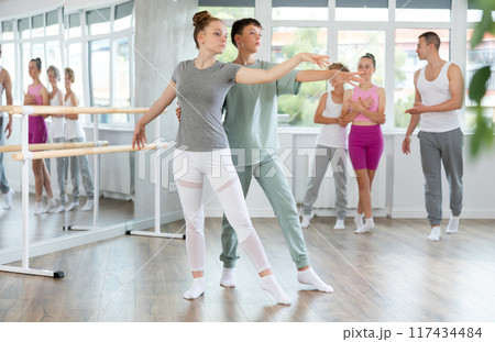 Boy and girl in pair train to perform ballet dance during rehearsal in studio Boy and girl in pair train to perform ballet dance during rehearsal in studio 117434484