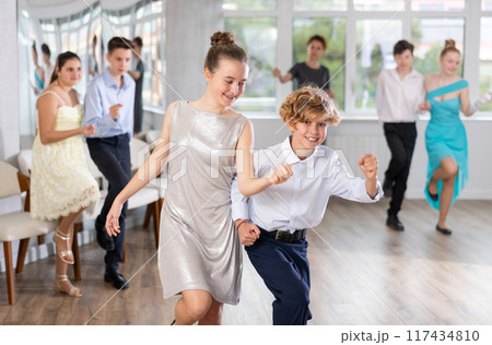 Enthusiastic adolescent girl and boy dancing in pair in dance studio 117434810