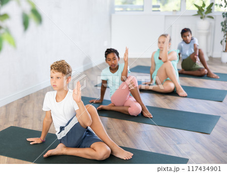 Little children practicing yoga indoors. 117434901