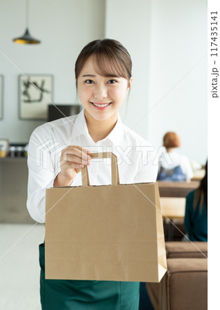 商品を渡す若い店員の女性 商品を渡す若い店員の女性 117435141