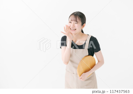 呼びかけをするエプロン姿の女性 呼びかけをするエプロン姿の女性 117437563