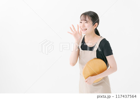 呼びかけをするエプロン姿の女性 呼びかけをするエプロン姿の女性 117437564