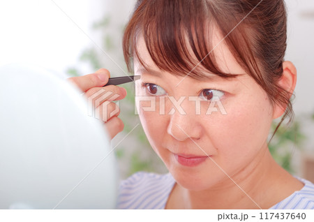 眉毛のケアをしているミドル女性 117437640