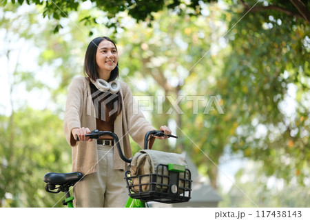 A woman is riding a bicycle with a basket on it 117438143