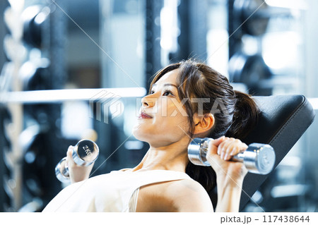 スポーツジムでトレーニングする若い女性 117438644