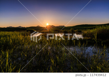 2024年夏曽爾高原お亀池周辺の夕景　西の空を黄金色に染めながら山際へ沈んで行く太陽⑥ 117439412