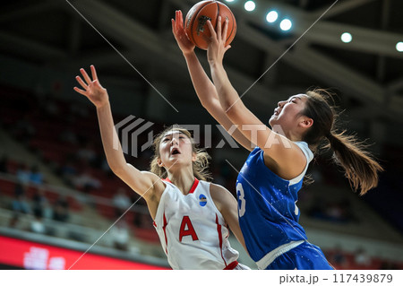 シュートする女子バスケットボールの選手とブロックしようとする相手選手_1 117439879