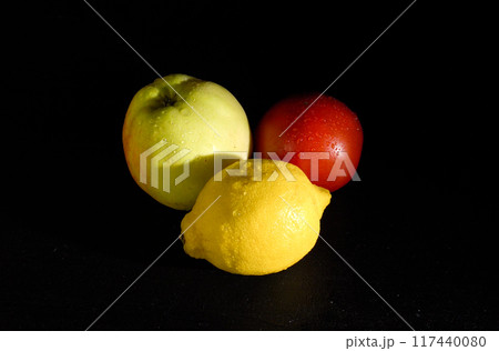 Ripe Yellow Lemon, Apple, and Tomato on a Black Background 117440080