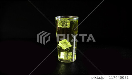 Lemonade with Rising Bubbles and Ice Cubes in Glass on a Black Background 117440081