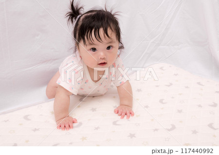 【はいはいを始める髪を結んだ赤ちゃん】 117440992