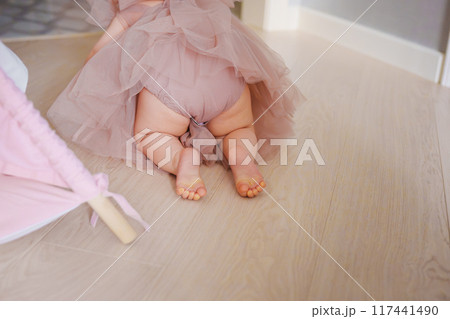 Cute little bare feet of baby girl. the child crawls on the floor. 117441490