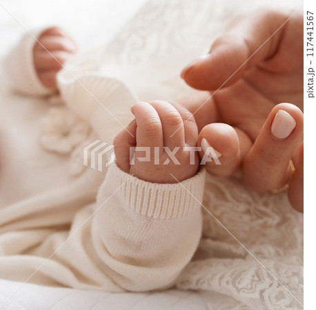 close-up. Mother's hand holds the small hand of a newborn baby. close-up. Mother's hand holds the small hand of a newborn baby. 117441567