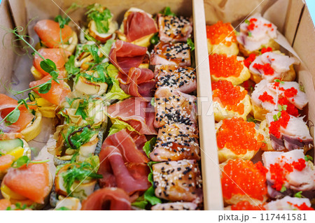 A box with an assortment of meat and fish appetizers for the buffet table. A box with an assortment of meat and fish appetizers for the buffet table. 117441581