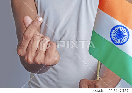 Man holding Indian flag with Korean mini heart gesture in front of body on white background. 117442587