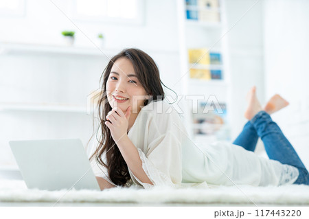 部屋でパソコンを見る女性 117443220