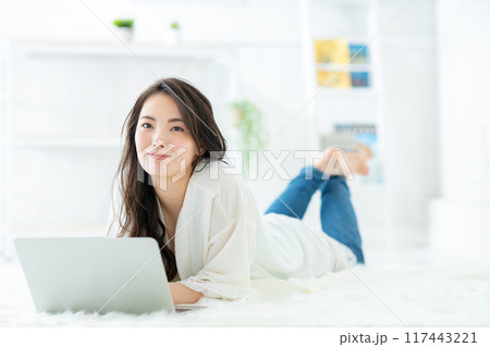 部屋でパソコンを見る女性 117443221
