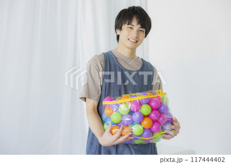 おもちゃを持つ保育士の男性 117444402