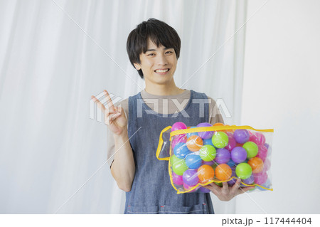 おもちゃを持つ保育士の男性 117444404