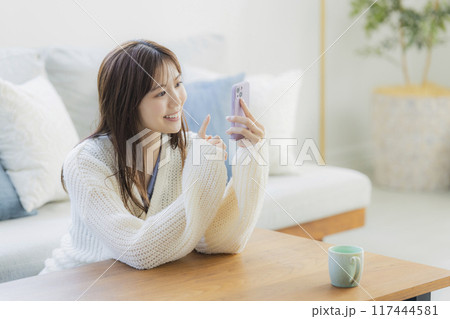 部屋でくつろぐニットの若い女性 部屋でくつろぐニットの若い女性 117444581
