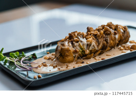 Stewed meat in mushroom sauce and herbs on a white plate 117445715