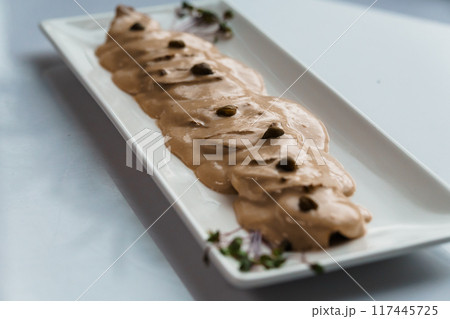 Stewed meat in mushroom sauce and herbs on a white plate Stewed meat in mushroom sauce and herbs on a white plate 117445725