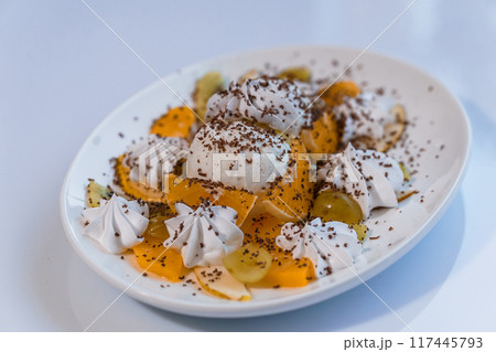 Ice cream with fruits and chocolate on a white plate 117445793