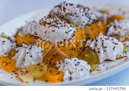 Ice cream with fruits and chocolate on a white plate 117445794