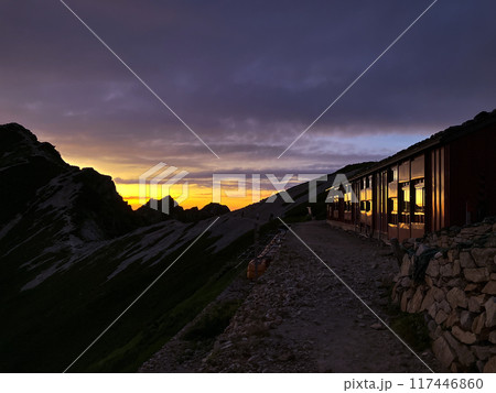 夕日に染まる唐松岳頂上山荘 117446860