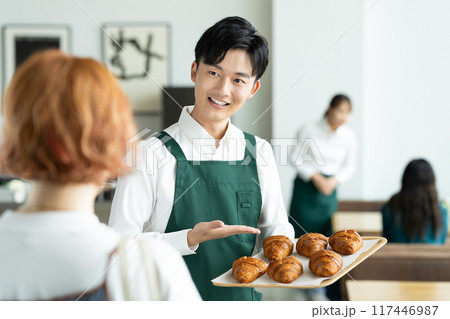 クロワッサンをすすめる若い男性の店員 クロワッサンをすすめる若い男性の店員 117446987