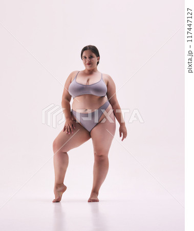 Empowered, beautiful plus size woman wearing grey underwear, standing strong and proud against white studio background. Empowered, beautiful plus size woman wearing grey underwear, standing strong and proud against white studio background. 117447127