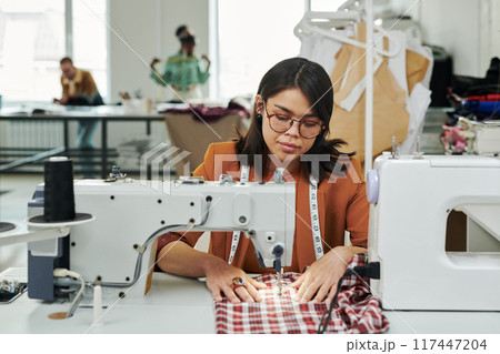 Young seamstress creating new attire 117447204