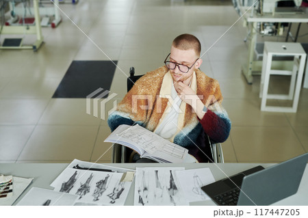 Man looking at sketch of trendy attire Man looking at sketch of trendy attire 117447205