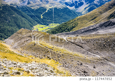 A panoramic view of the Sulden Valley in Italy, showcasing lush greenery amidst rugged mountains under a clear blue sky during summer. A panoramic view of the Sulden Valley in Italy, showcasing lush greenery amidst rugged mountains under a clear blue sky during summer. 117447852